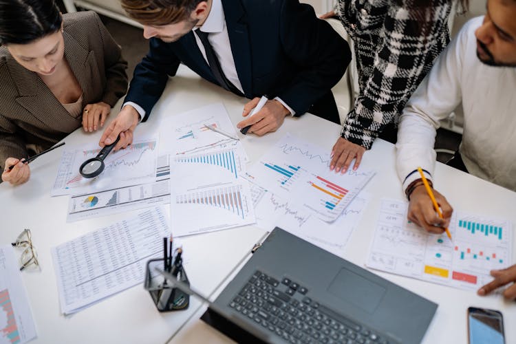 People Working Together By Table At Office