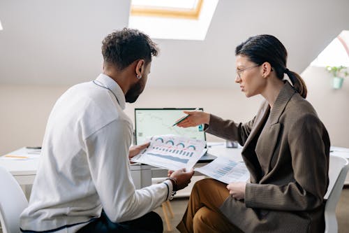 Woman in Suit Sitting with Man and Working