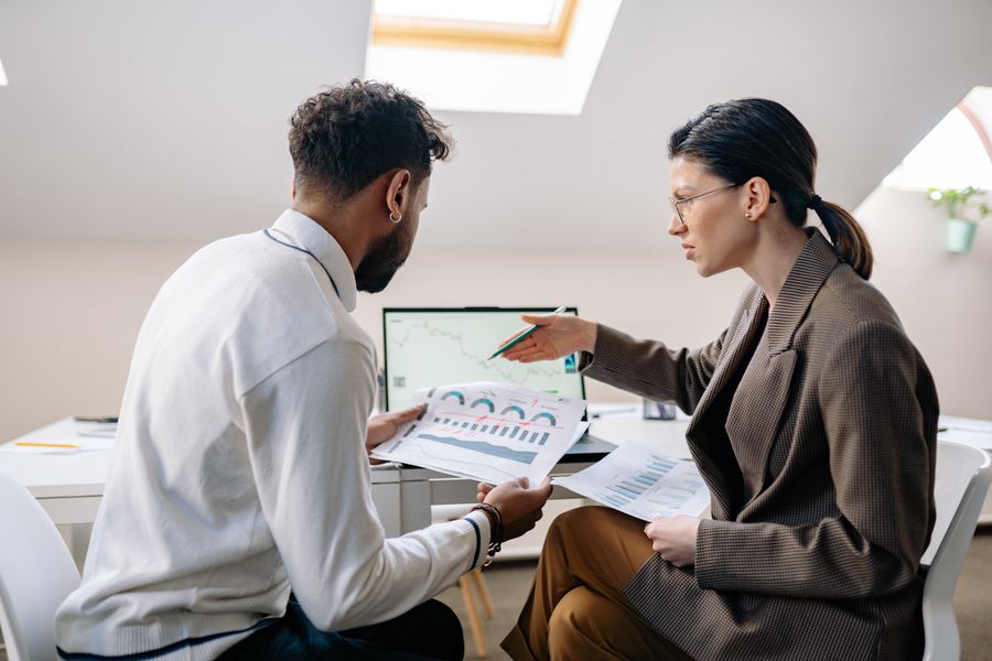 Two business partners discussing paperwork at a table