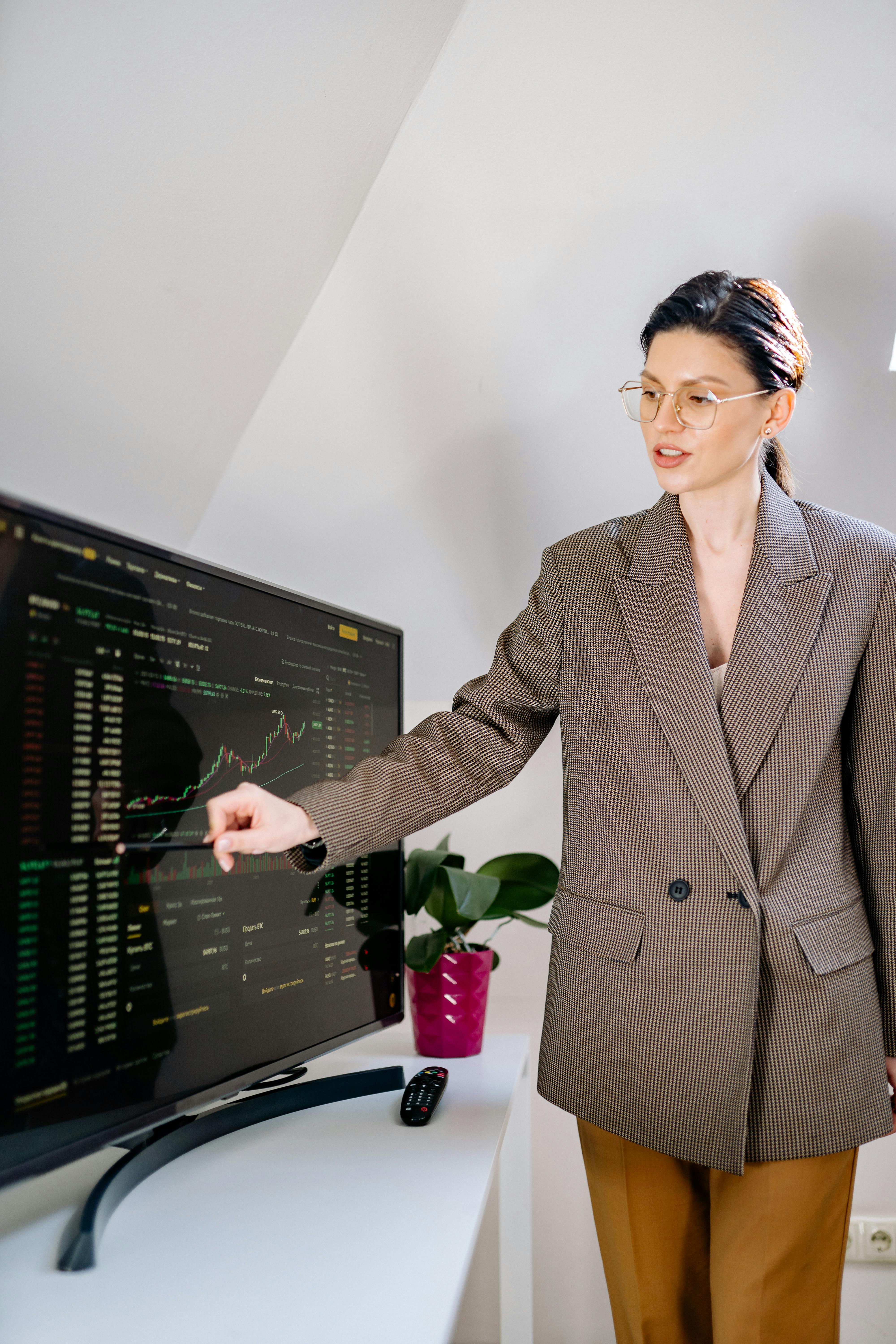 woman in brown blazer holding a stylus pen