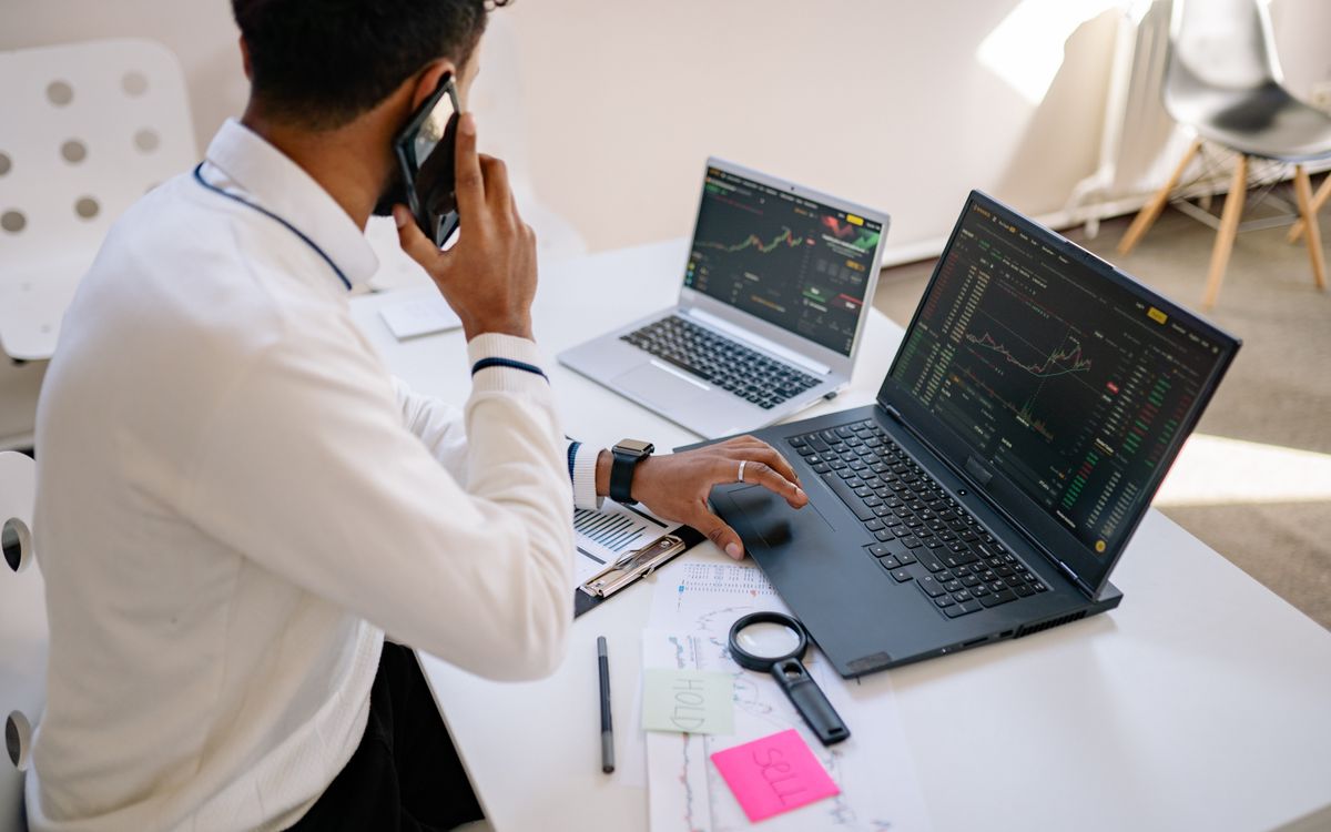 Indian marketing manager reviewing performance dashboards on two laptops