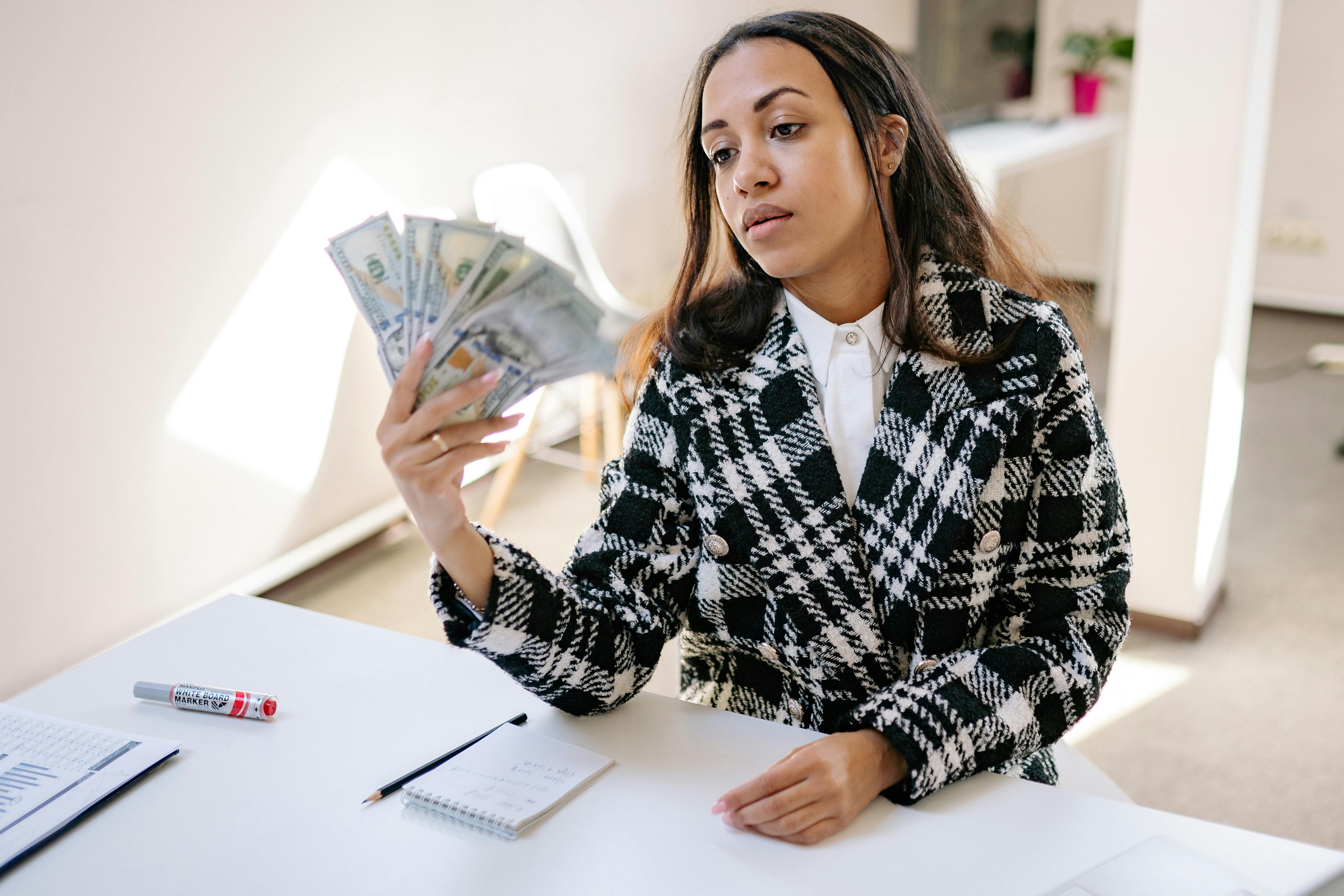 a woman in plaid coat holding money