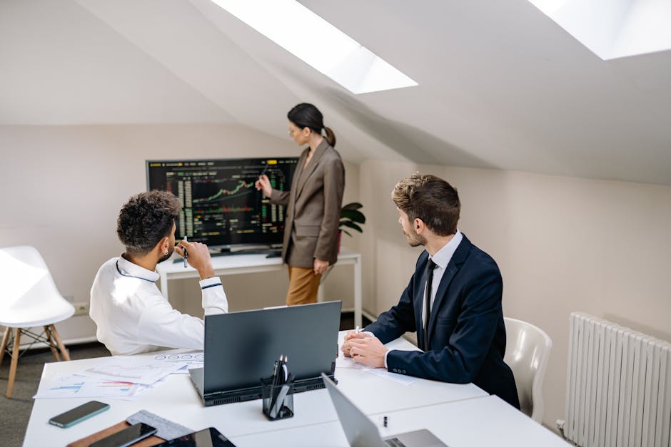 Vanguard vs Betterment: Retirement Fee Showdown Professionals discussing stock market trends with charts in an office setting.