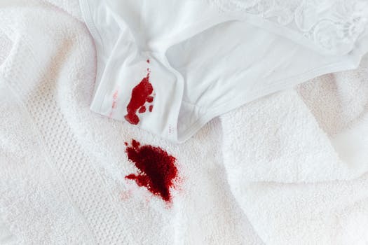 Close-up of menstrual blood stain on white underwear and towel, symbolizing period awareness.
