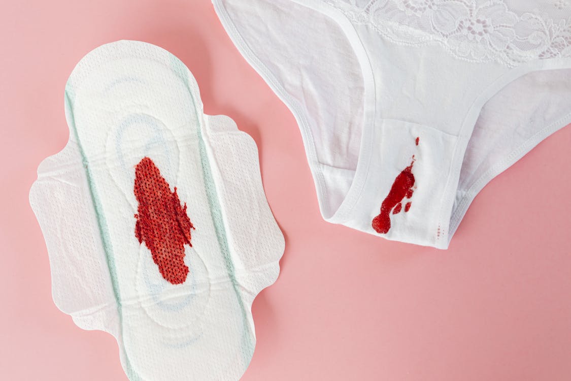 Almofadas Da Menstruação Com Os Grânulos Vermelhos Como Gotas No Fundo  Cor-de-rosa, Dias Críticos Do Sangue Das Mulheres, Ciclo G Foto de Stock -  Imagem de dias, madeireiras: 152643002