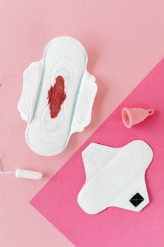 Various menstrual hygiene products on a pink background, illustrating period care.