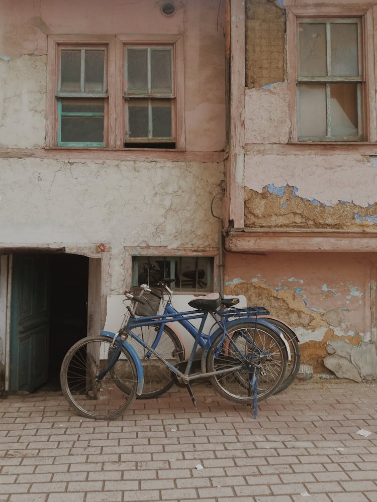 Old Bicycles By Building Wall