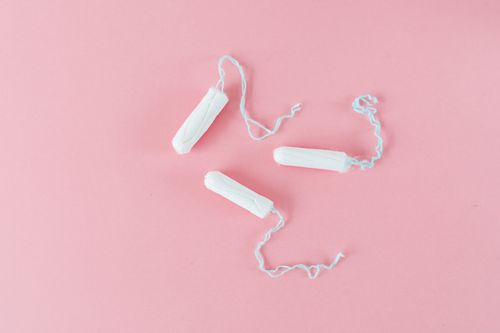 Free Minimalist image of three white tampons on a pink background, ideal for health topics. Stock Photo