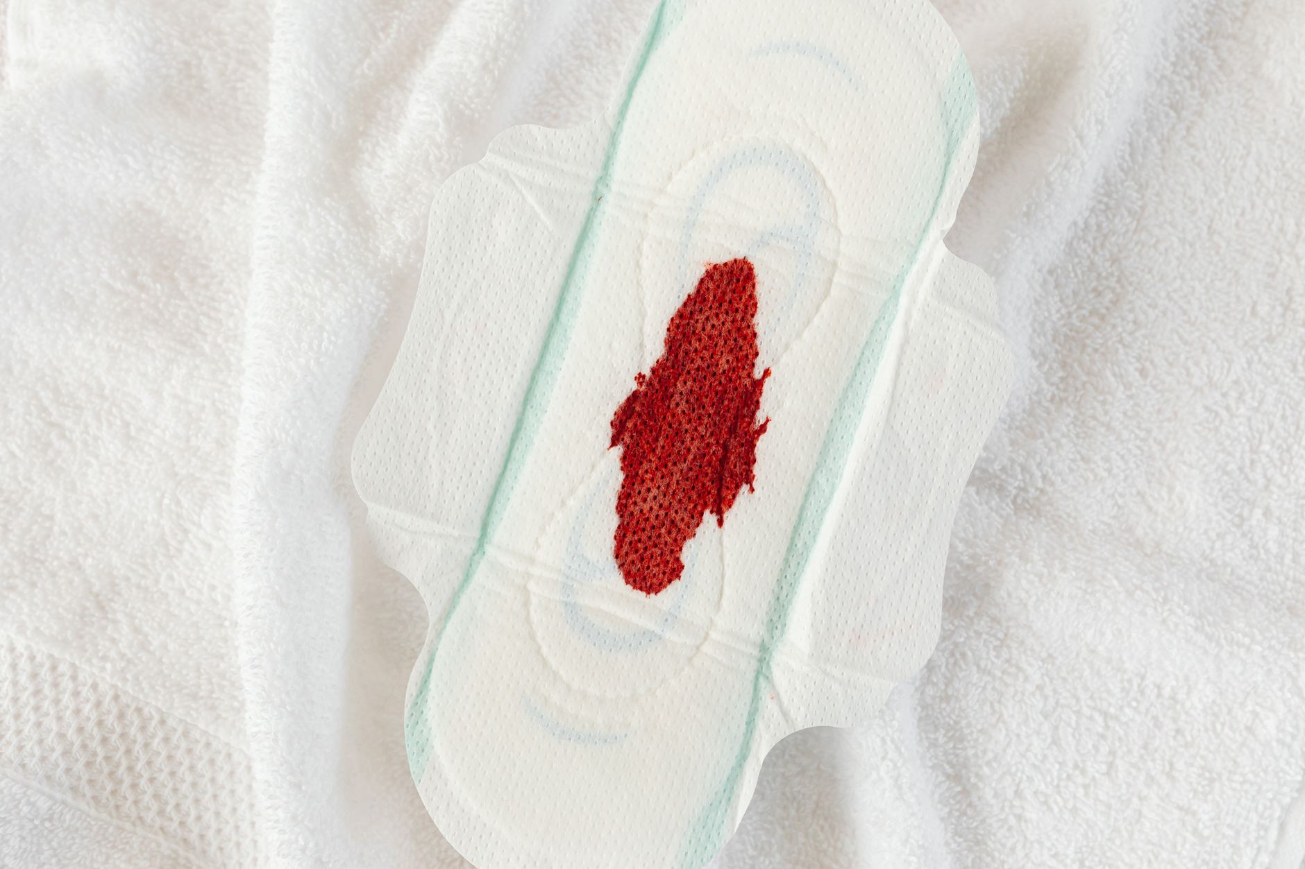 diosmin hesperidin for long covid circulation — Detailed view of a sanitary pad with a blood stain, highlighting menstruation theme.
