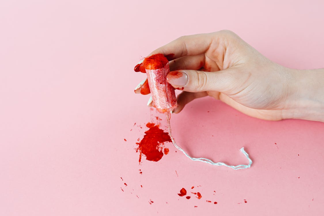 Photo of a Tampon With Blood Stains Being Held