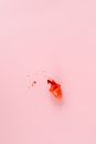 A Menstrual Cup with Blood Spilled on a Pink Colored Surface