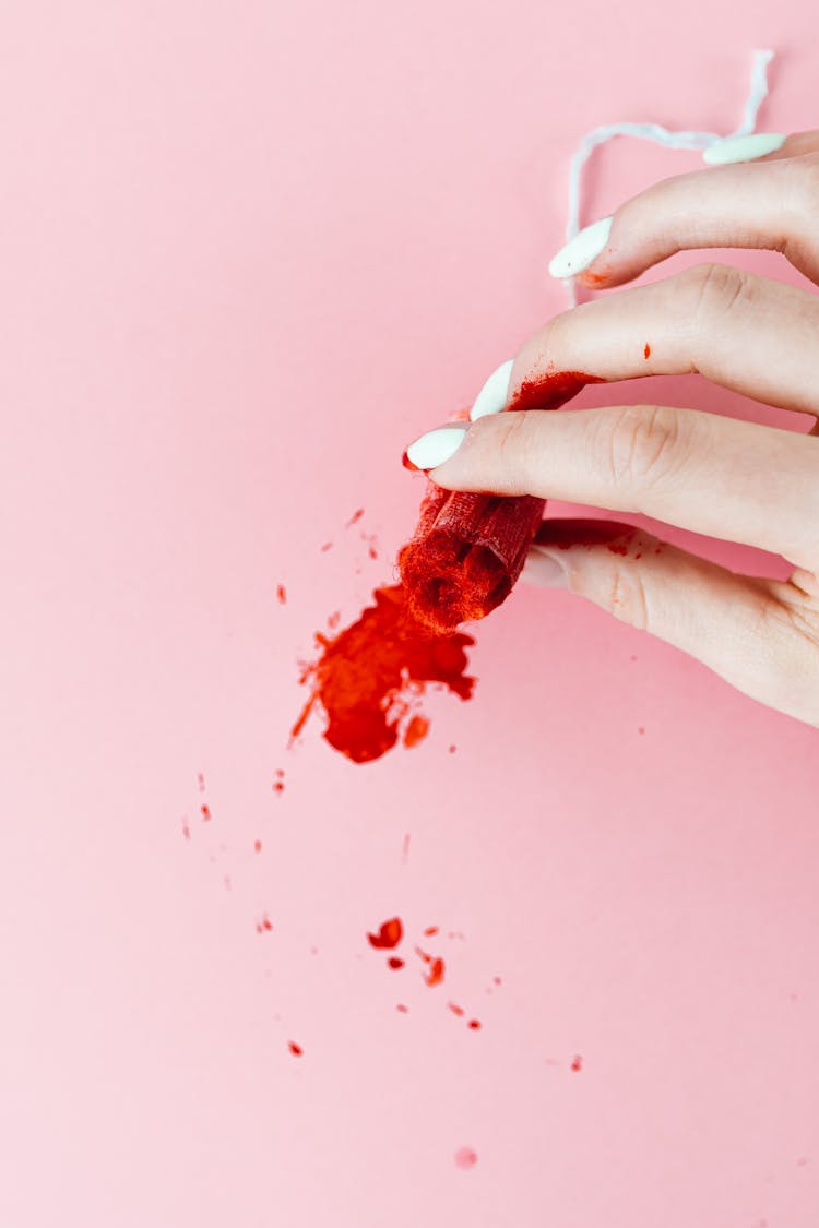 Close-Up Shot Of A Person Holding A Tampon With Blood