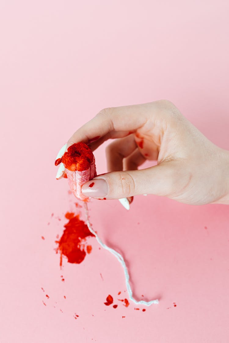 A Person Holding Tampon With Blood