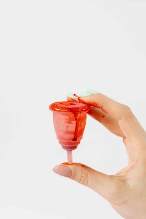 A Person Holding a Menstrual Cup on a White Background 