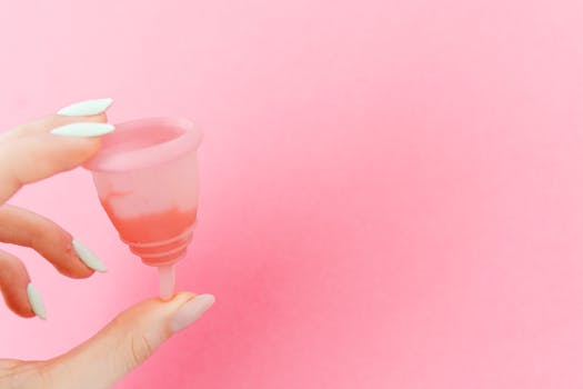 Close-up of a menstrual cup on a pink background, highlighting menstrual care.