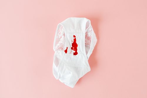 Free White lace underwear with visible menstrual stain on pink background. Stock Photo