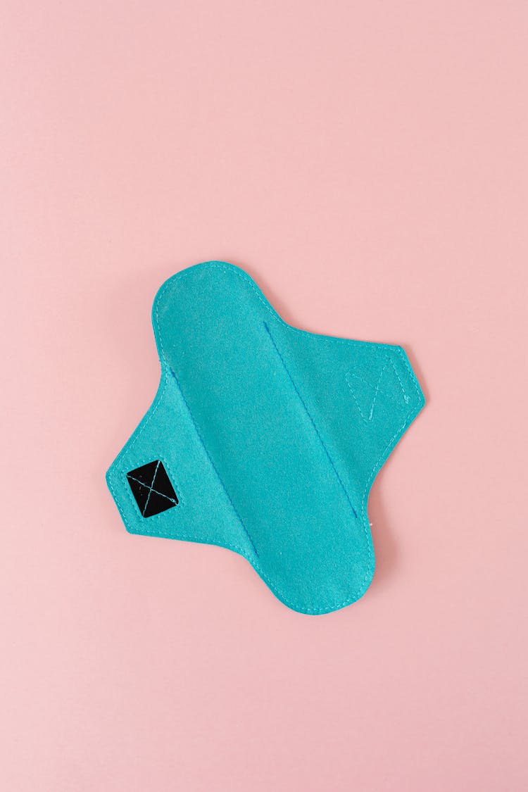 A Blue Reusable Menstrual Pad On Pink Surface
