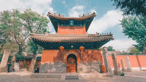 Free Traditional Chinese temple with red lanterns under a blue sky, showcasing historic architecture. Stock Photo
