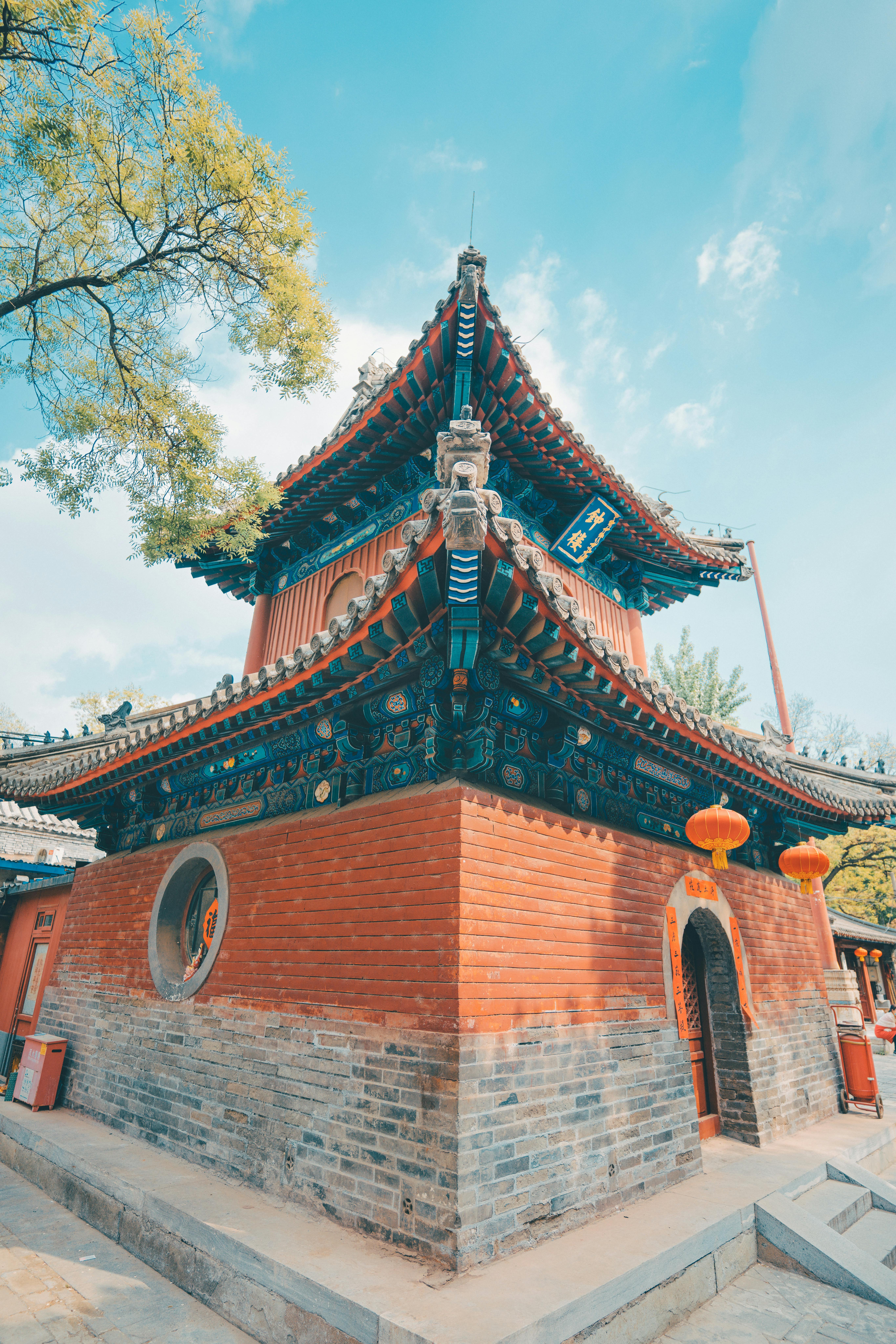 Free Ornate architecture of a traditional Chinese temple corner with vibrant decorations and clear sky. Stock Photo