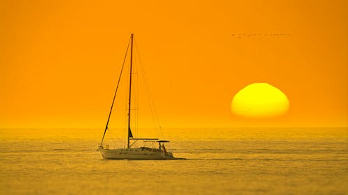 Kostenlos Weißes Boot In Der Mitte Des Meeres Während Des Sonnenuntergangs Stock-Foto