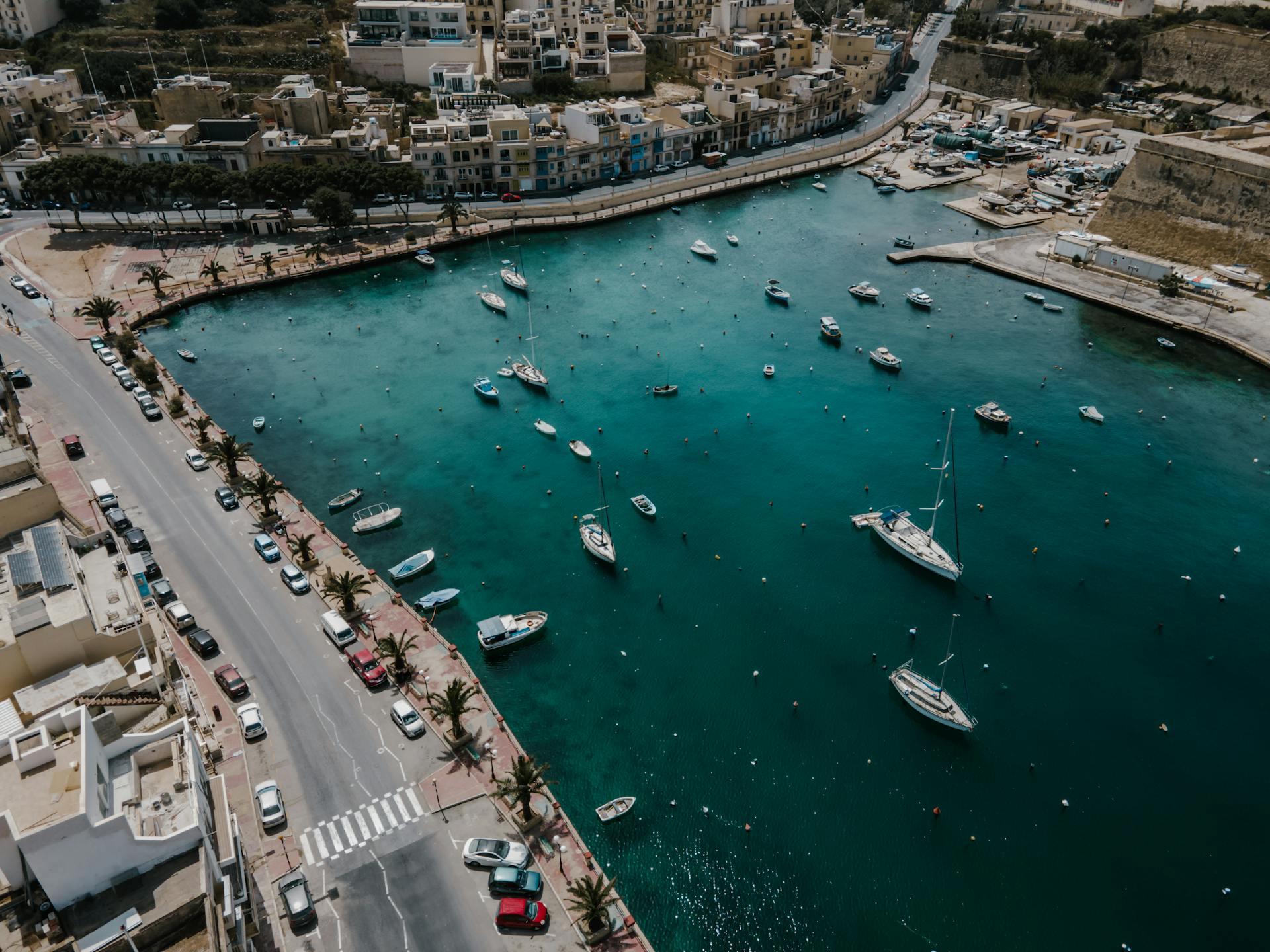 Stunning aerial view of Il-Kalkara harbor in Malta with boats and turquoise waters.