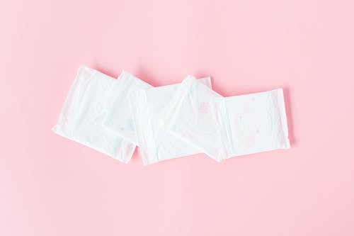 Foto profissional grátis de absorvente, almofada menstrual, fundo cor-de-rosa