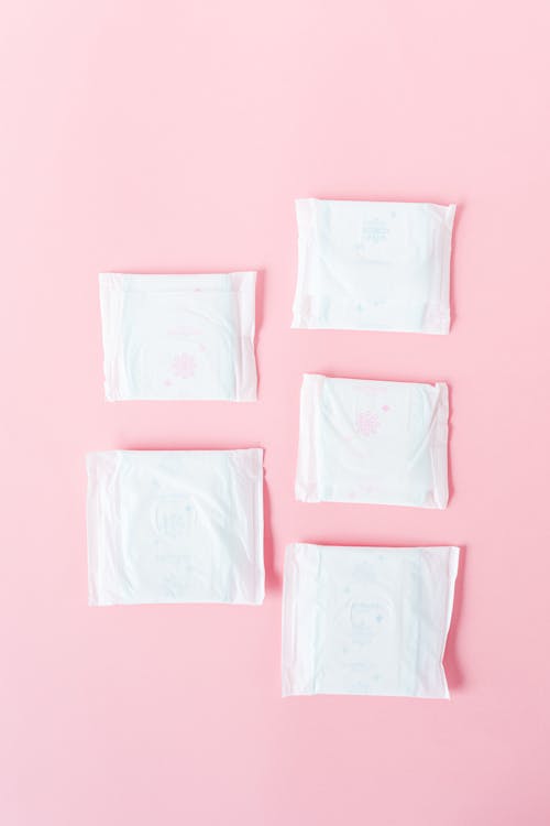Fotos de stock gratuitas de almohadilla menstrual, flatlay, fondo rosa