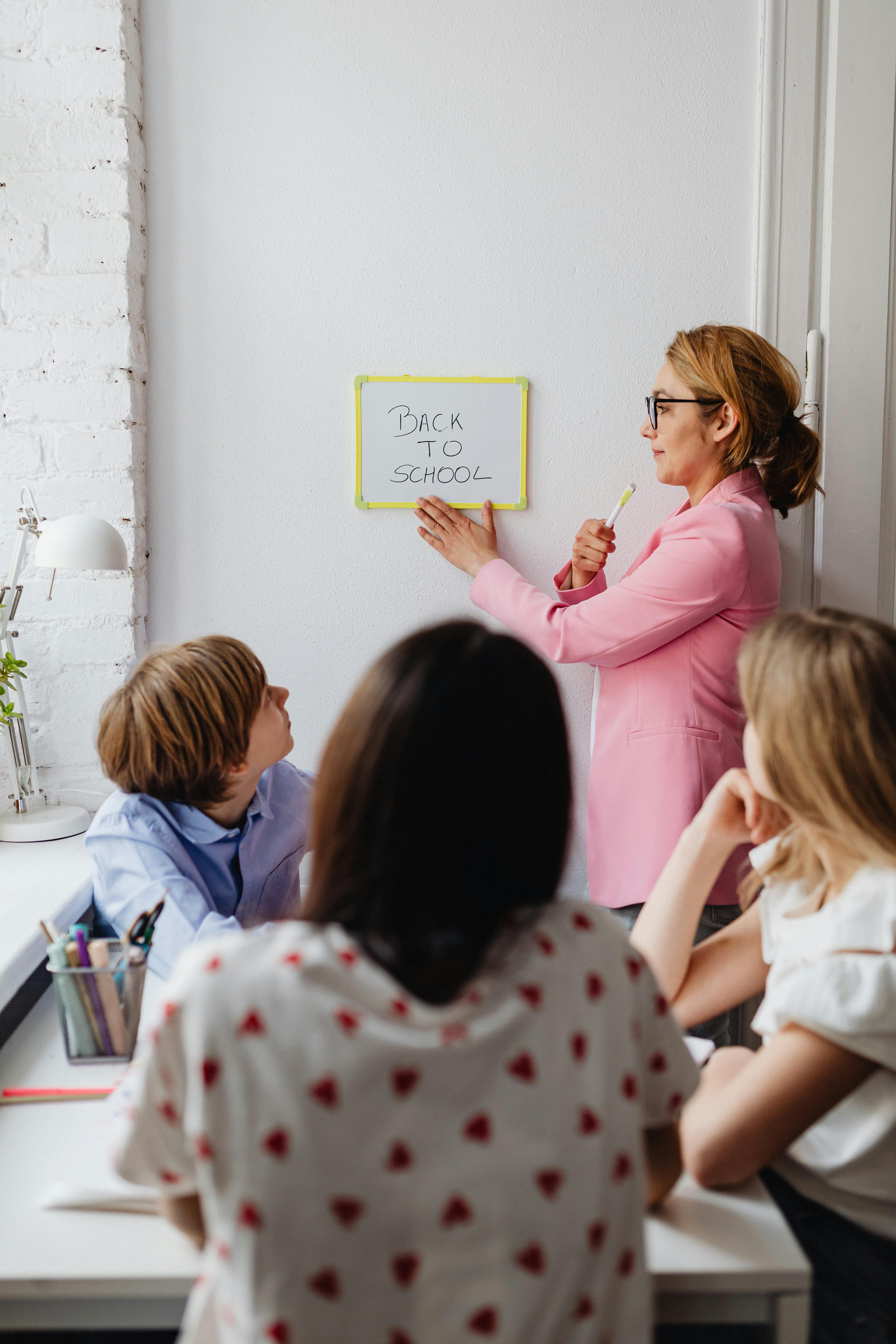 teacher holding a whiteboard with back to school text