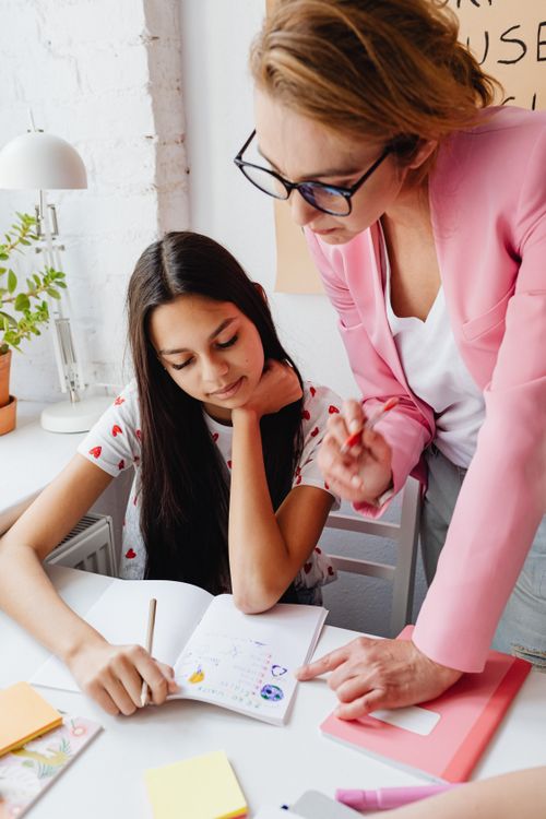 Free A teacher guiding a teenager in a creative school project indoors. Stock Photo