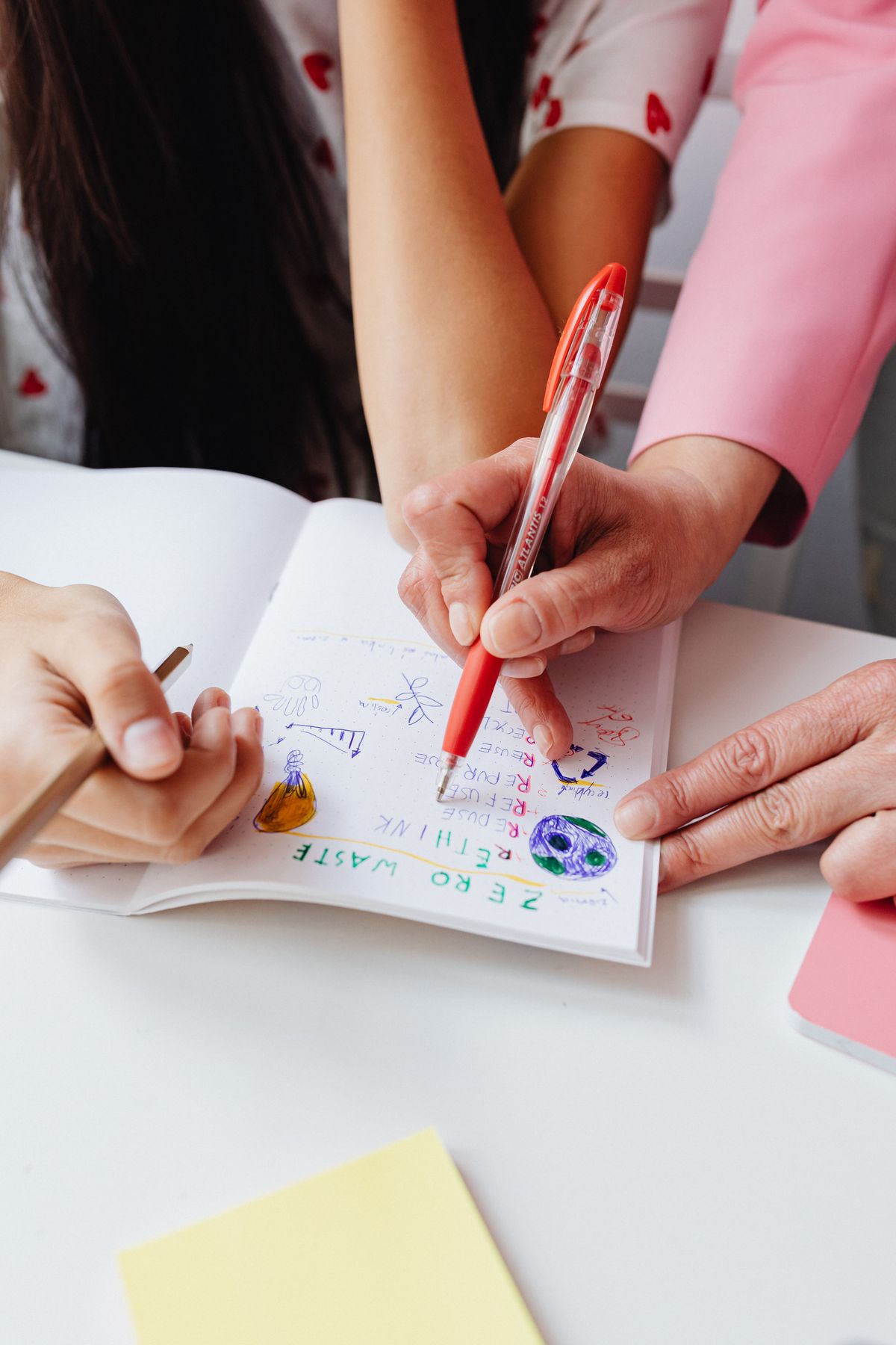 Person marking essay corrections with a red pen while learning how to proofread your own essay