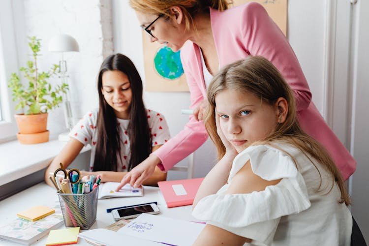 Teacher Over Girls Working On Project