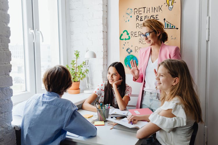 Smiling Teacher Over Girls Working On Project