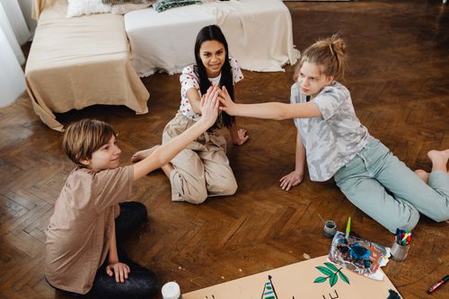 Free Three teenagers engaging in a creative art project indoors, embracing teamwork and imagination. Stock Photo