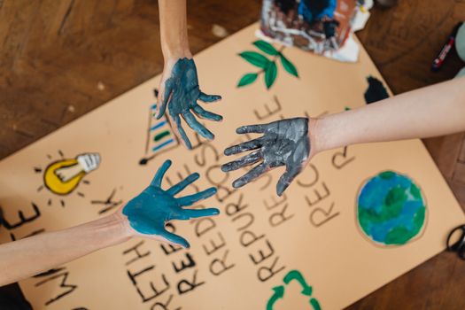 Colorful hands reaching towards creative school project poster.