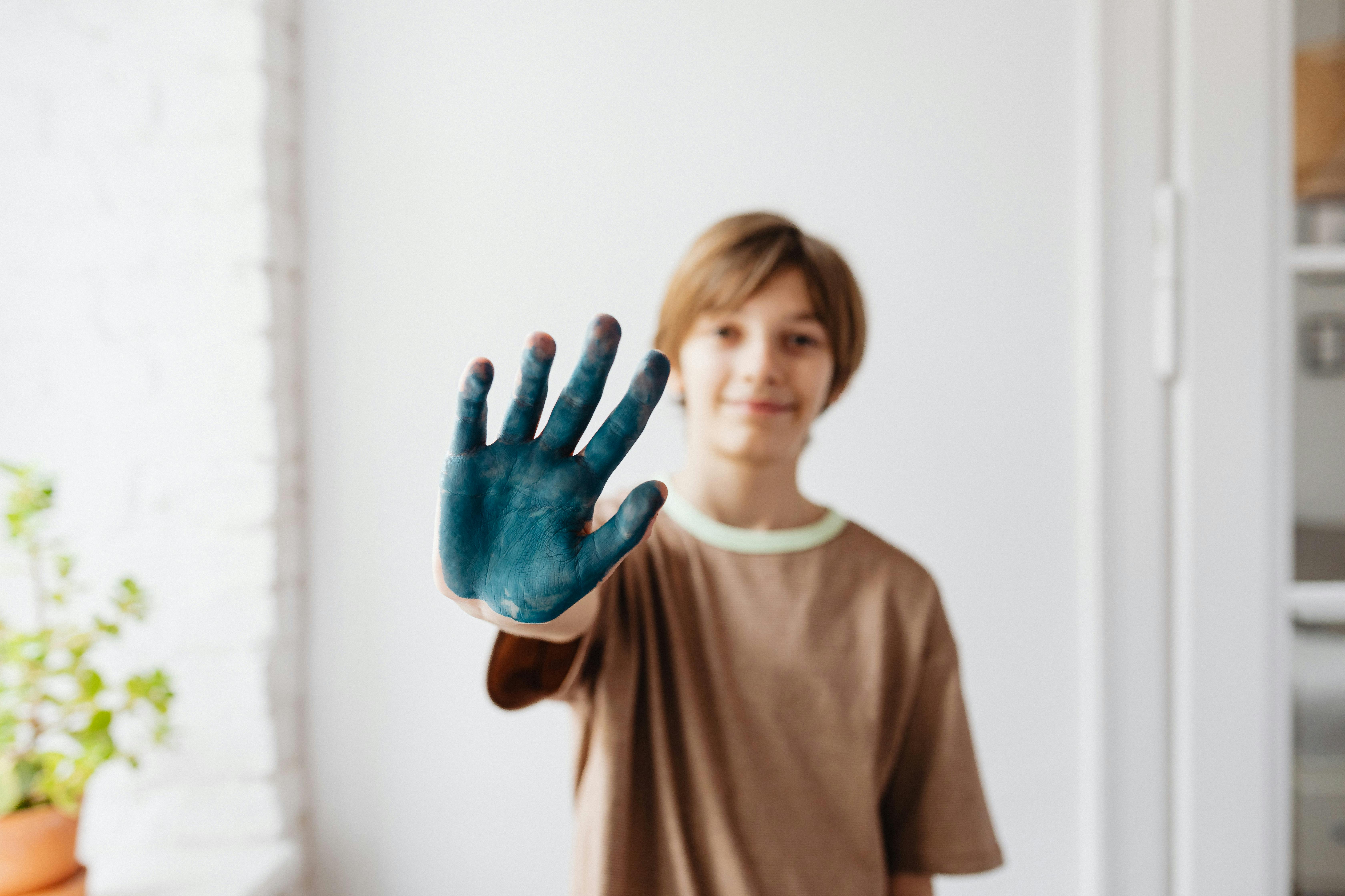 a boy in brown shirt showing his hand