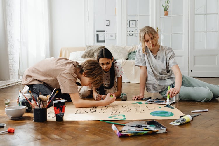 Teenagers Sitting On Floor And Working On Project