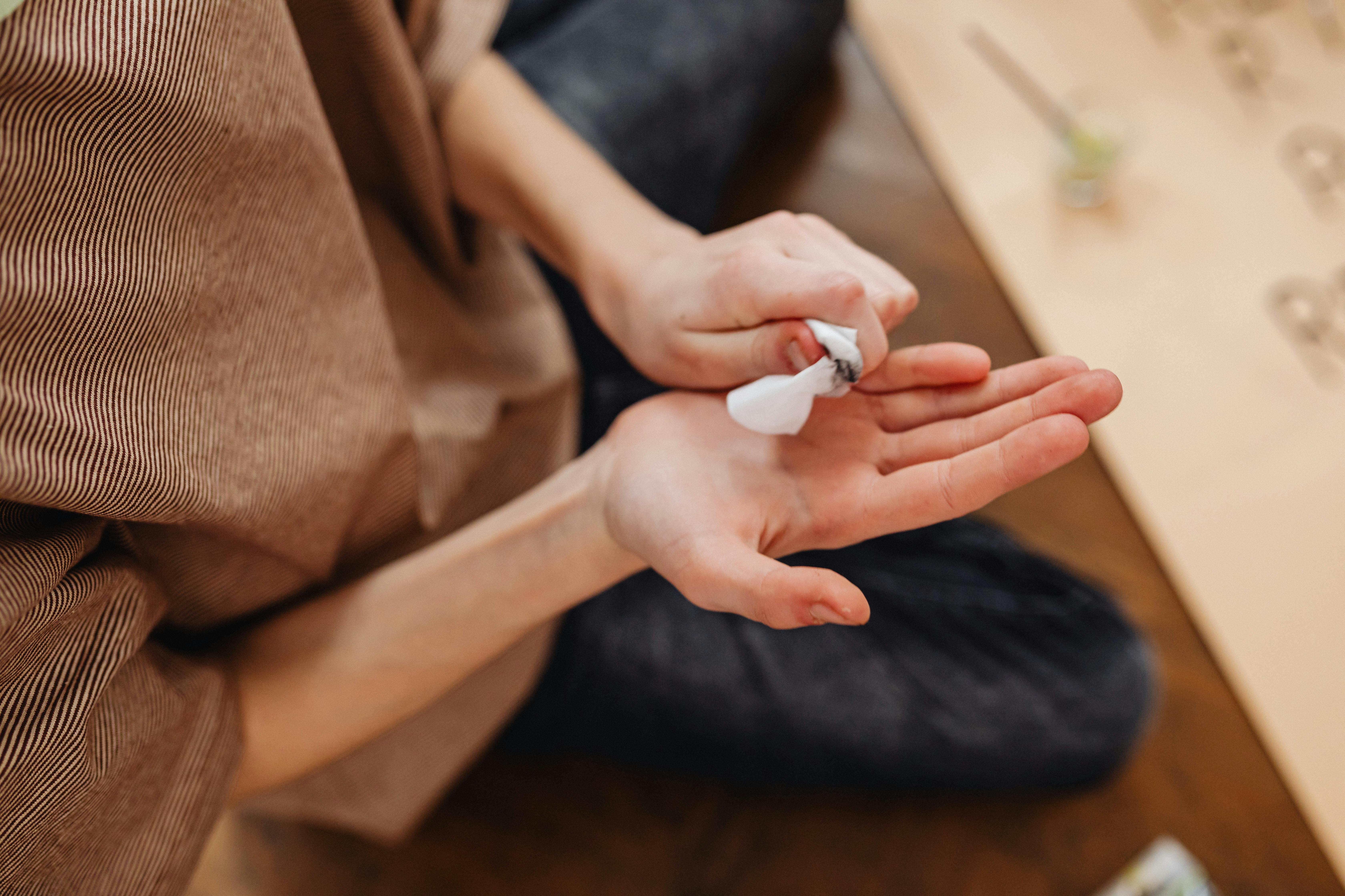 Close-up of person's hands holding crumpled white paper indoors, creating a thoughtful moment.