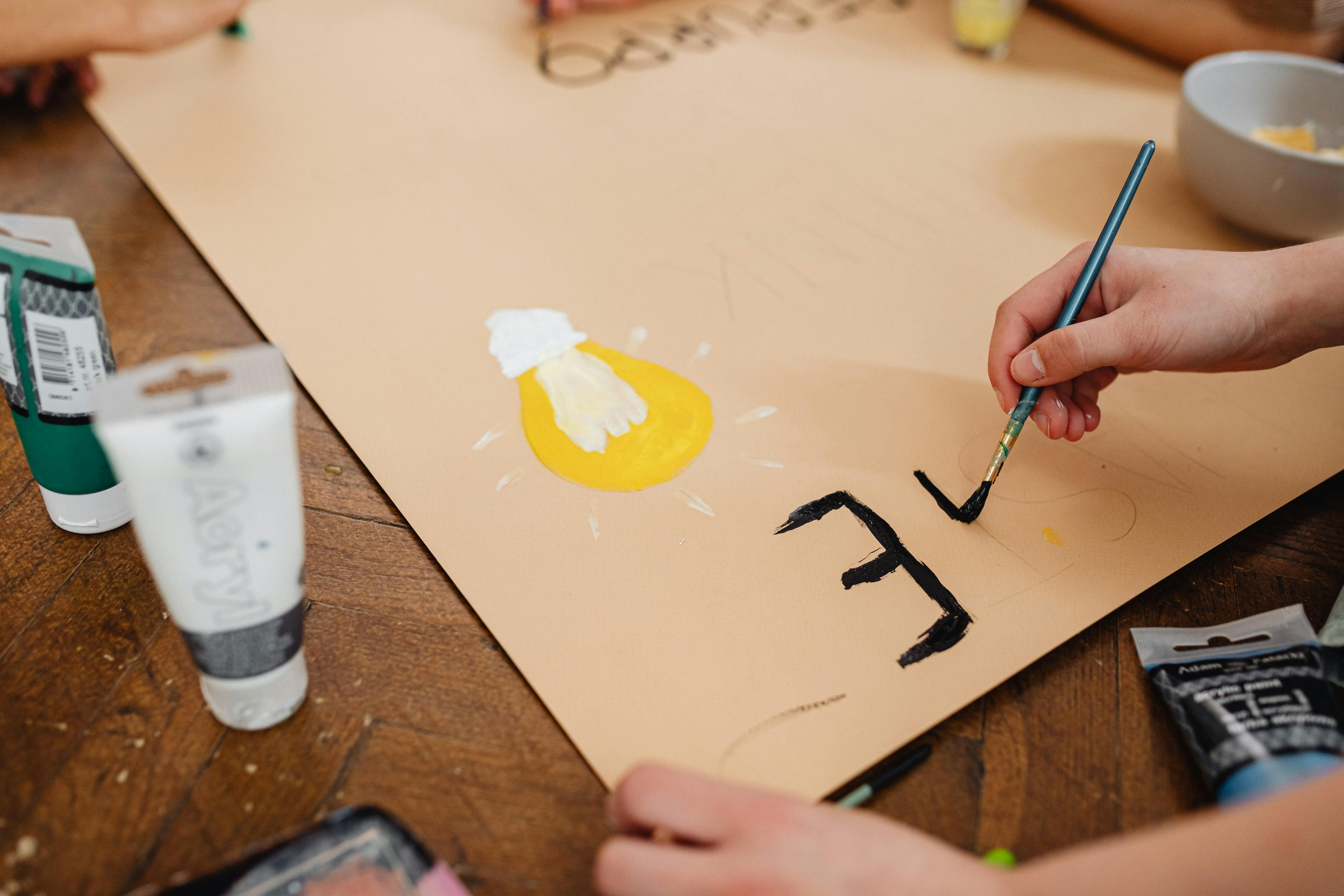 a person painting on brown paper