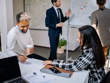 Diverse group of coworkers discussing at a meeting in a bright, modern office space.