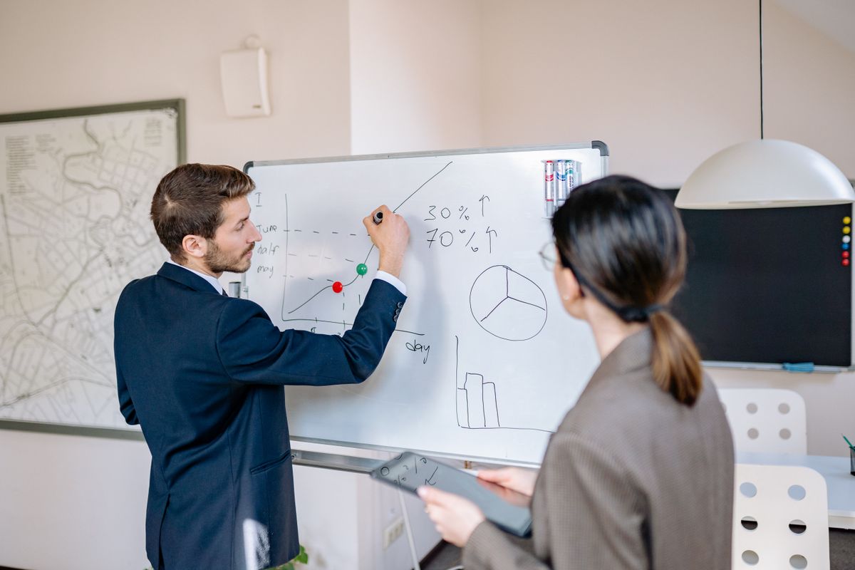 Two colleagues planning a system at a whiteboard