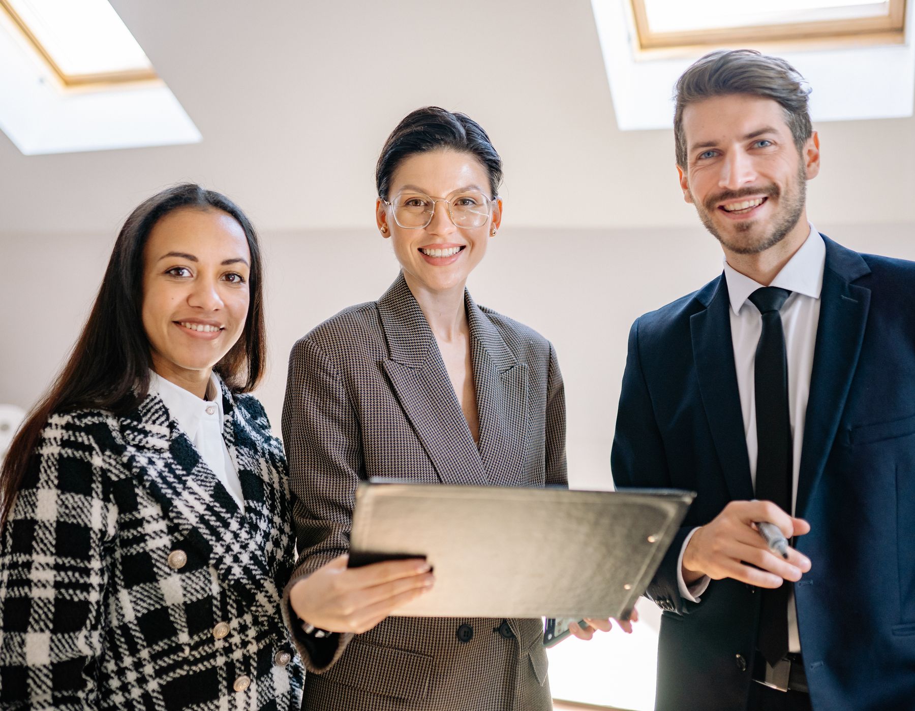 Diverse team of professionals smiling confidently at the camera in a modern office