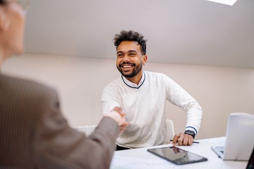 Free Smiling businessman shaking hands in a modern office. Professional teamwork and agreement concept. Stock Photo