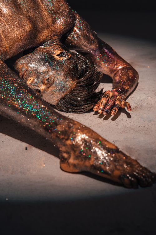 Free A creative display of body art with glitter and gold on a model's skin, capturing the essence of modern expressionism. Stock Photo