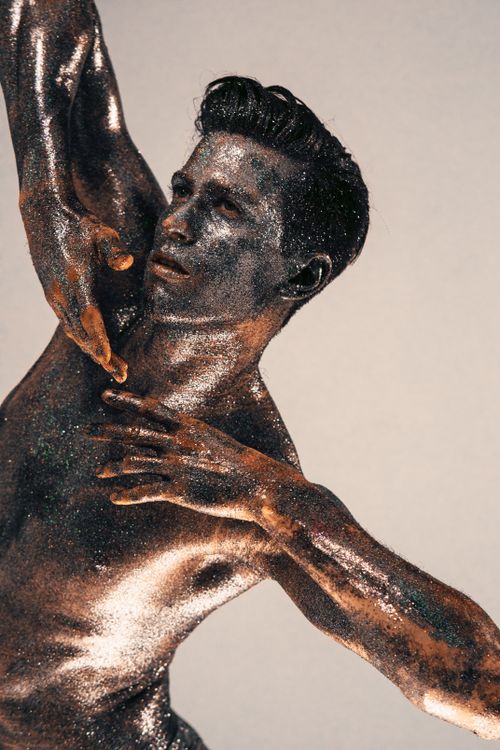 Free Artistic portrait of a shirtless man with body covered in glitter, posing creatively. Stock Photo