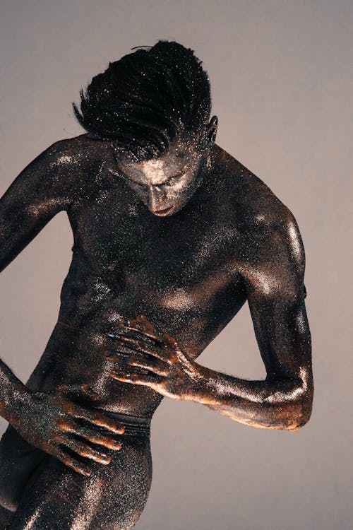 A Man with Body Paint and Glitters Posing in Underwear