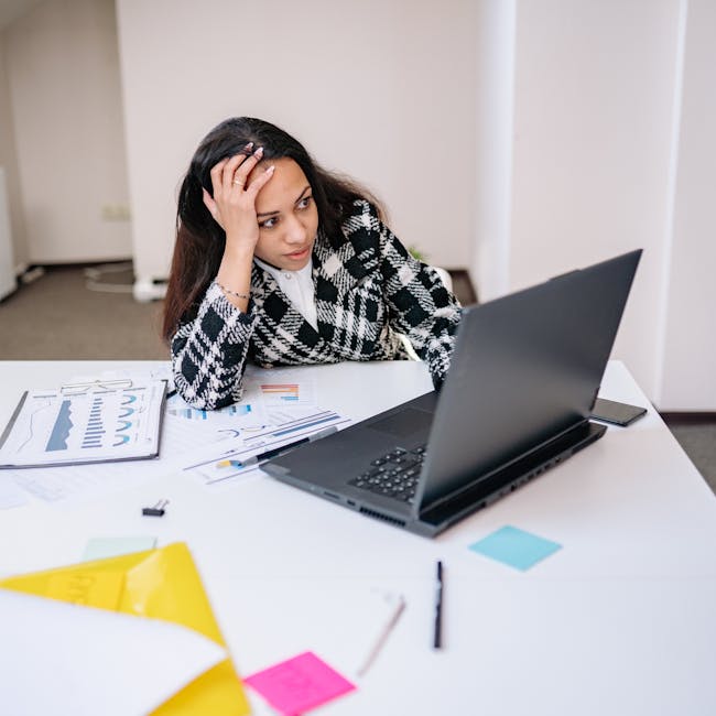Person looking frustrated at a spinning buffering icon on a laptop screen