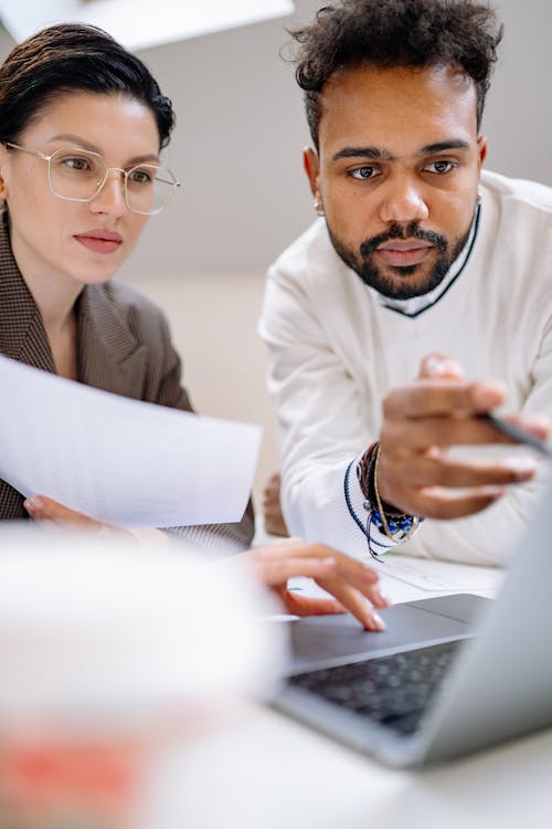 A Man and a Woman Looking at a Laptop