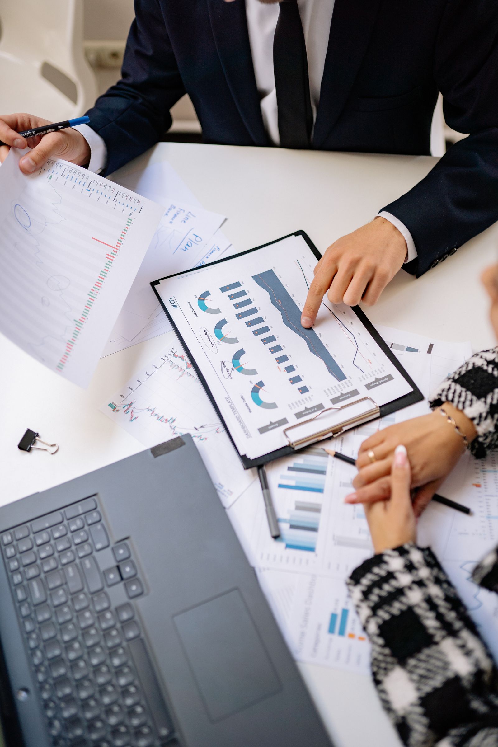 Free Teamwork in a modern office setting with charts and laptops showcasing collaboration. Stock Photo