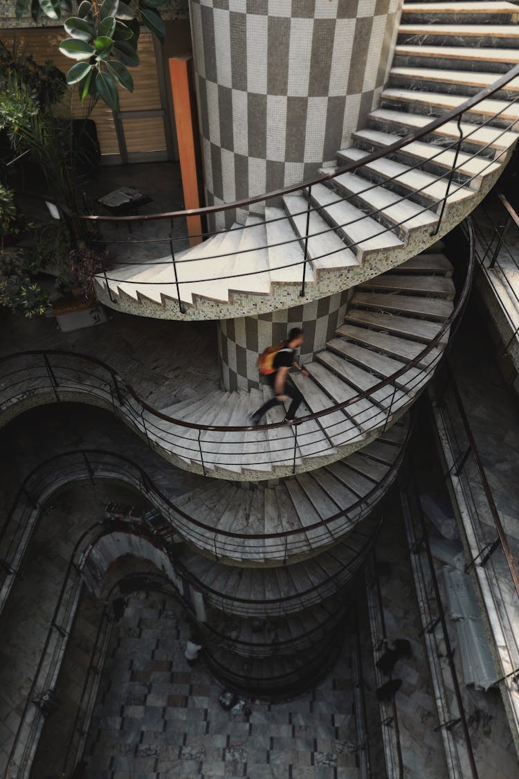 Faceless Man Walking On Spiral Staircase