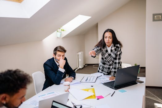 A diverse team working on a project in a modern office setting, with charts and laptops displayed.